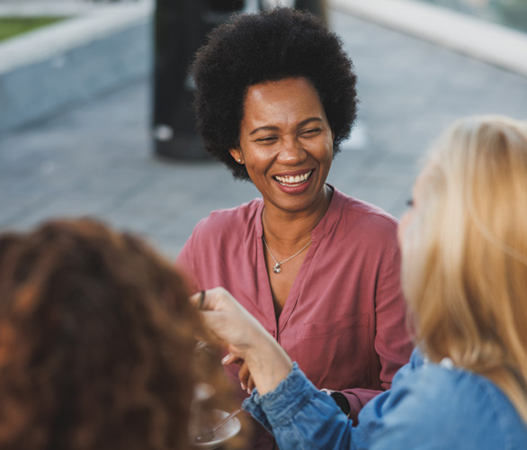 3 women casually talking to one another in a group