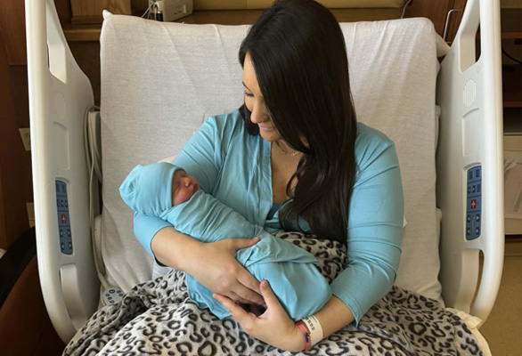 HCH Mom Brooklyn holding baby in HCH hospital bed