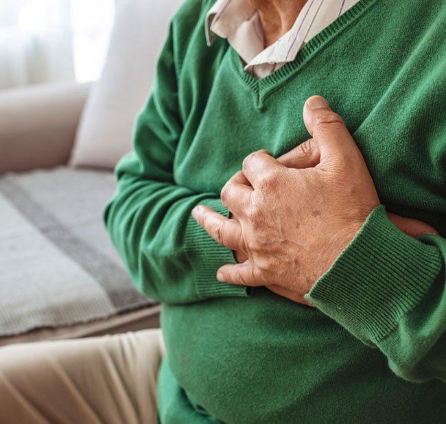 Man sitting down and has his hands on his heart