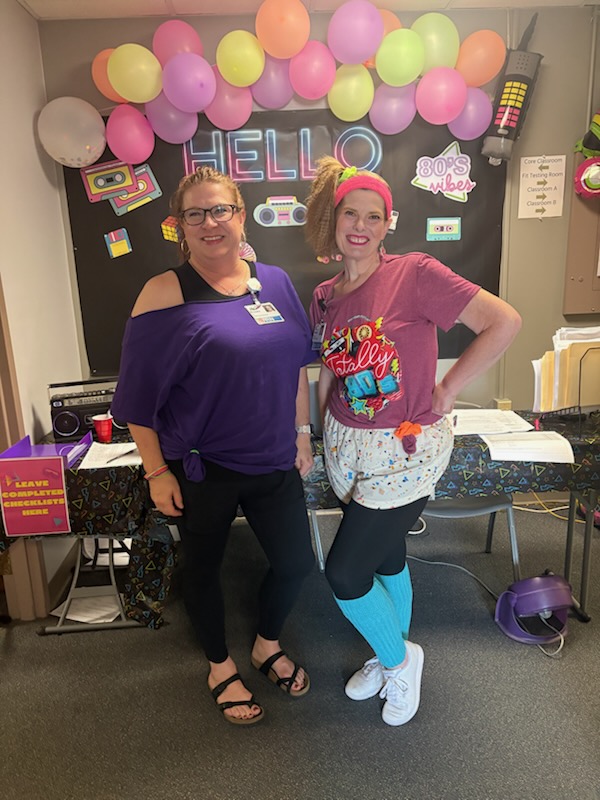 Staff development team members wearing 80's themed outfits for competencies