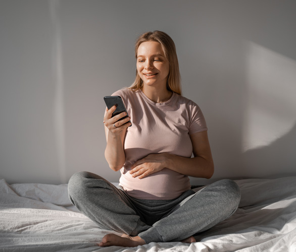 An expectant mother scrolling on her phone looking for pregnancy resources