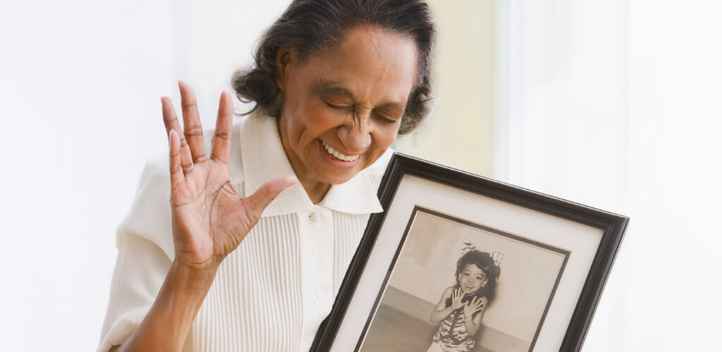 Senior woman holding a photo of her younger self dancing