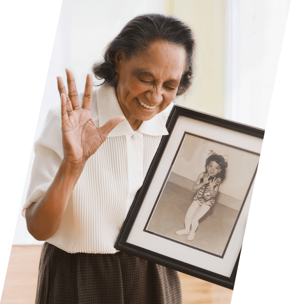 Senior woman holding a photo of her younger self