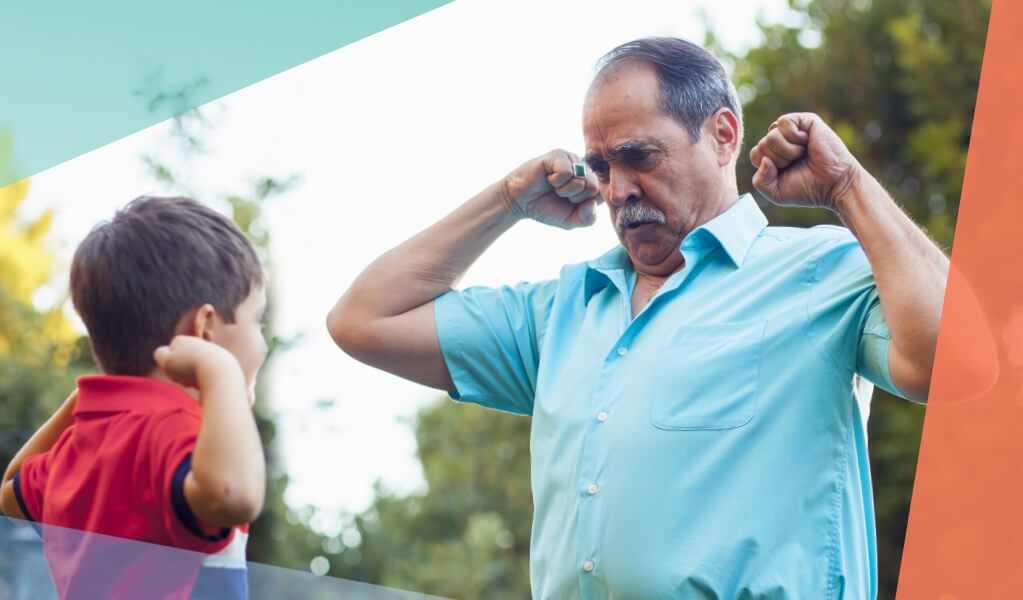 father and son showing their muscles to each other focus on father's shoulders