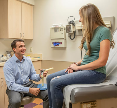 Dr. Strong discusses quad-sparing knee replacement options with a patient