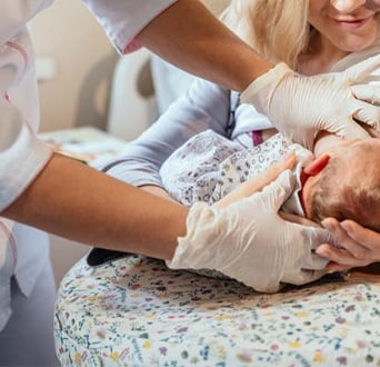 First time mother learning how to breastfeed her newborn baby