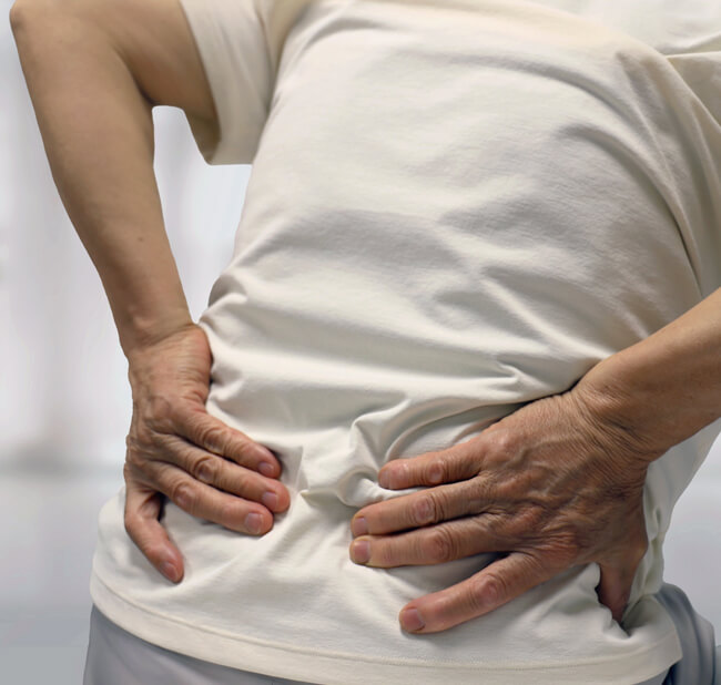 patient holding lower back in pain
