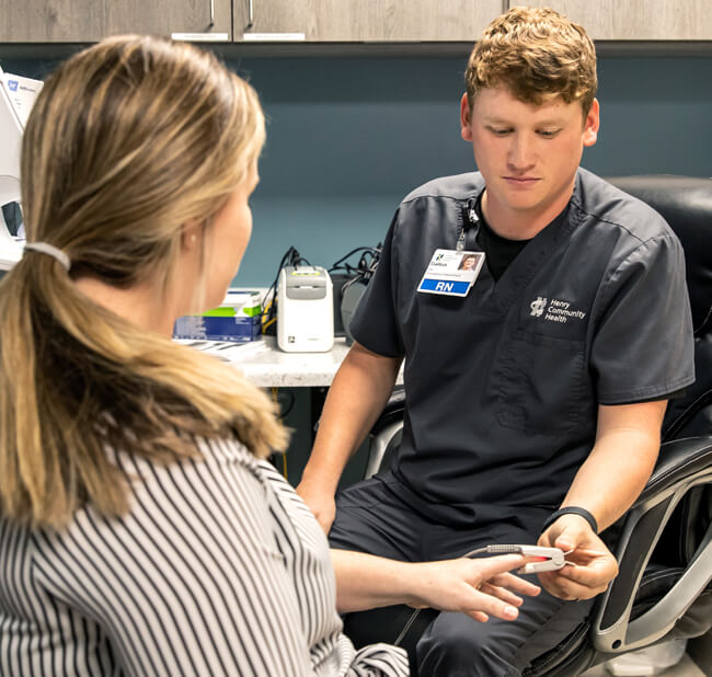 RN taking patient's blood pressure in immediate care clinic