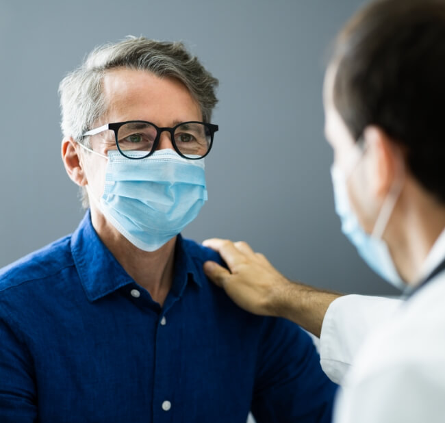 Man with doctor wearing mask as protection from infectious diseases